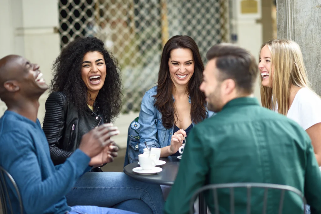 multiracial group five friends having coffee together